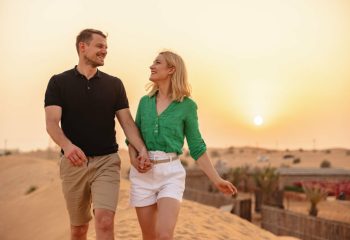 couple enjoying a romantic walk while holding hands in the desert in Dubai.