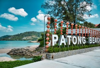 calm sandy crescent Patong Beach with turquoise blue clear water and cirrus cloudy sky
