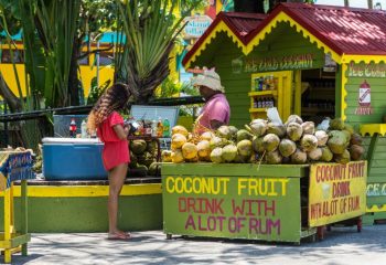 Ice Cold Coconut Fruit Drink with Rum stall/corner shop in rasta colors at the Ocho Rios Cruise Ship Port in the streets of Ocho Rios, Jamaica.